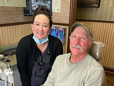 patient smiling at Georgia Dental Studio after getting a dental bridge that helped restore his smile