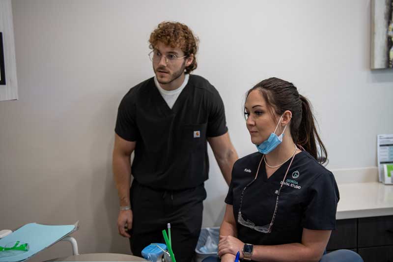 Staff members discussing restorative dental options at Georgia Dental Studio. 